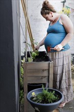 Pregnant woman at a flowerbed