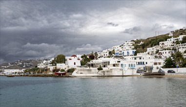 Cycladic white houses and Greek Orthodox white church with red roof
