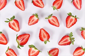 Top view of strawberry fruit halves arranged on white background