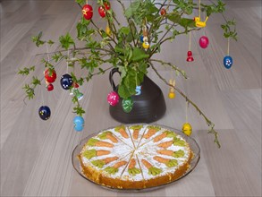 Homemade carrot cake in front of a shrub with Easter decorations