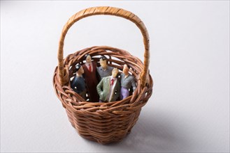 Tiny figurine of group of men miniature model in basket