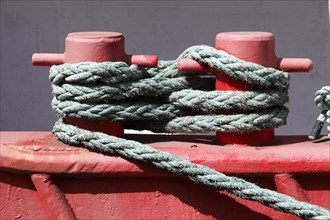 Red ship's bollard wrapped with ship's rope
