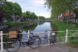 Bicycles leaning against the railing of an idyllic canal