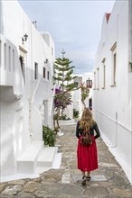 Young woman with red skirt in the alleys of Ano Mera