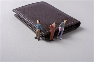 Tiny figurine of men miniature model beside a wallet
