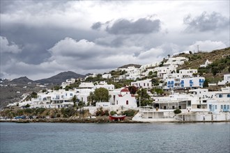 Cycladic white houses and Greek Orthodox white church with red roof