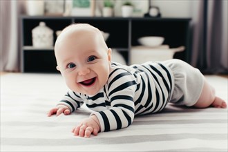A laughing baby in a striped romper suit