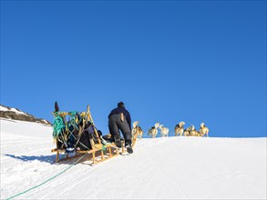 Inuit with his dog sled team