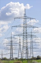 High-voltage pylons in front of cloudy sky