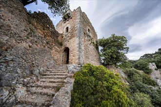 Stone steps and tower of the castle ruins Castell Alaro