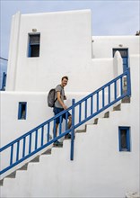 Young man on a staircase with blue railing