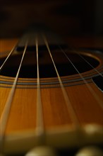 Close-up of the strings of a guitar against a black background
