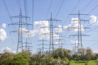 High-voltage pylons in front of cloudy sky