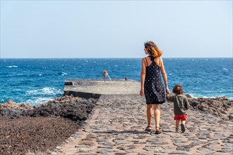 Mother and son at the pier in Orchilla on the southwest coast of El Hierro. Canary Islands