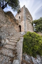 Stone steps and tower of the castle ruins Castell Alaro