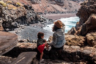Mother and son in the recreational area for barbecues on the Verodal beach on El Hierro Island. Canary Islands