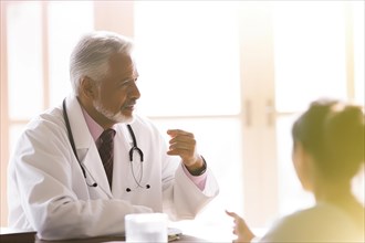An elderly doctor talking to a patient