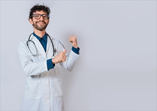 Smiling doctor pointing back isolated. Doctor pointing back with his thumbs