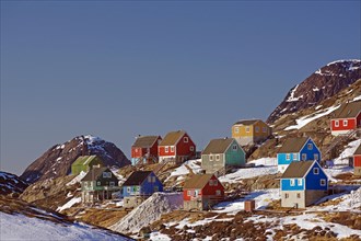 Wooden houses in different colours in winter landscape