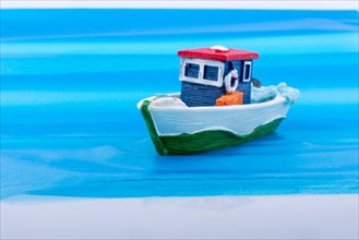 Little colorful model boat with windows on blue background