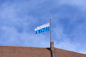 Waving Bavarian flag on the roof of the Kaiserburg