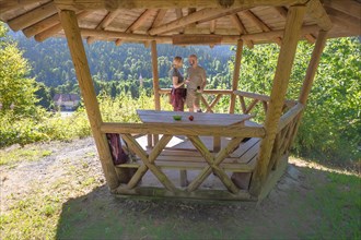Hiking couple taking a break in wooden pavilion on the hiking trail Sprollenhaeuser Hut