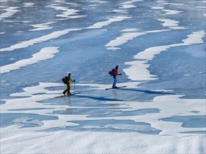 Ski mountaineers crossing a frozen lake
