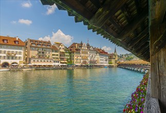 Chapel Bridge With Flowers and Luxury Hotel in City of Lucerne and Reuss River in Switzerland