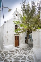 Small alley with white Greek Orthodox church