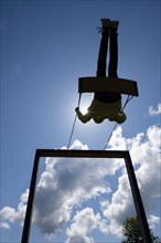 Silhouette of a child on a swing against the sky