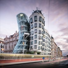 Rush hour with tram at colourful sunset at the Dancing House in Prague
