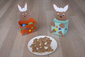 Plates of homemade Easter bunny biscuits in front of homemade Easter nests