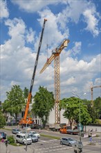 A construction crane is erected with a truck-mounted crane