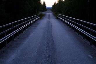 Bridge railing on a small country road in the bright Nordic night in midsummer