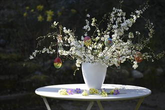 Easter bouquet with hand-painted Easter eggs in a vase in the garden