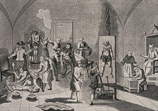 The interior of a prison of the Spanish Inquisition with a priest overseeing his scribe while men and woman are hung from pulleys
