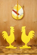 Two yellow wooden rooster figures