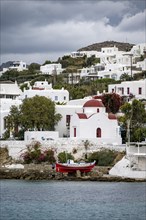 Fishing boat and small Greek Orthodox white church with red roof