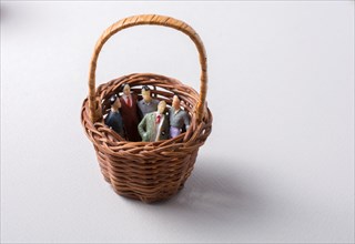 Tiny figurine of group of men miniature model in basket