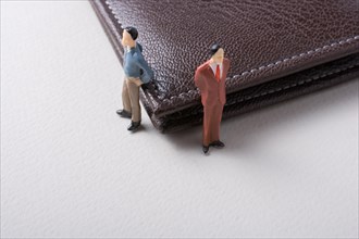 Tiny figurine of men miniature model beside a wallet