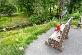 Aerial view of woman on oversized bench in spa gardens