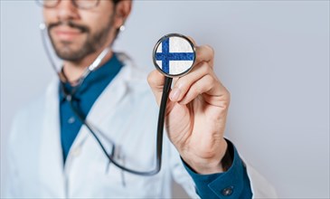 Doctor holding stethoscope with Finland flag. Finland Health and Care Concept
