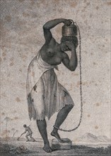 A slave woman carrying a weight on her head. A Woman Carrying a Weight on Her Head Attached to Her Ankle by a Chain