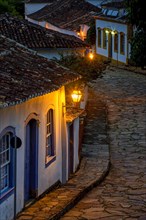Night image of a slope with cobblestones and colonial-style houses in the old town of Tiradentes in Minas Gerais