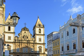 Facade of an old historic church and colorful colonial-style houses in the central square of the Pelourinho district in Salvador city