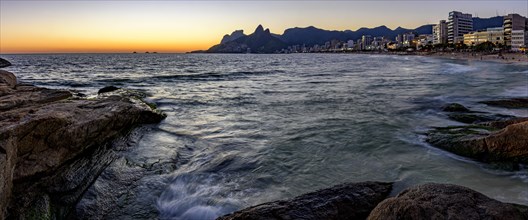 Panoramic image of the sunset at Ipanema beach in Rio de Janeiro with the sea
