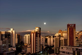 City of Belo Horizonte in the southeastern region of Brazil seen at dusk with the full moon over the buildings