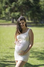 Portrait of pregnant latina woman in a park
