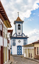 Street with cobblestones and colonial-style houses with a historic church in the background in the famous city of Diamantina in Minas Gerais