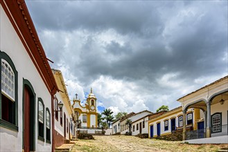 Street and old colonial style houses in the historic city of Tiradentes in Minas Gerais with a baroque church in the background